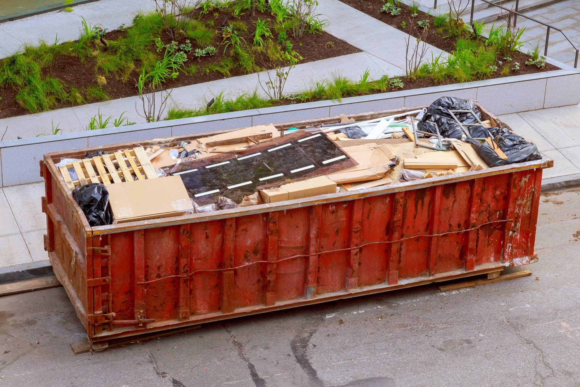 Container mit Sperrmüll, Holz und Kartons bei einer Entrümpelung